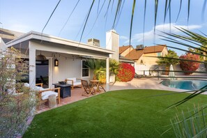 A modern house with a covered patio, a swimming pool, and a well-maintained lawn. - Resort-Style Chandler Retreat | Heated Pool • Firepit • BBQ (Chandler)