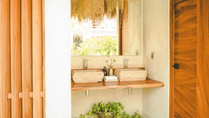 A bathroom with wooden shelves, a mirror, and a potted plant. - Bidmont Villa Spa (Puerto Escondido)