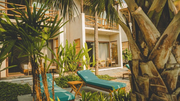A resort with a pool area, lounge chairs, and a two-story building with a balcony. - Bidmont Villa Spa (Puerto Escondido)