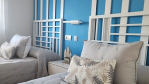 A bedroom with a large bed, two bedside tables, and a wall with a blue and white striped pattern. - CT 362 AL First Line Beachfront Vera Playa ID 791 (Vera)