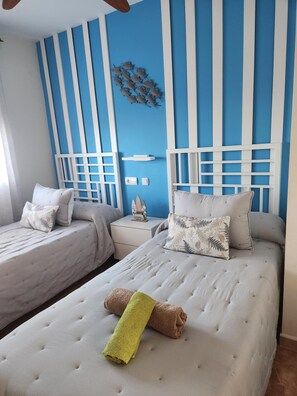 A room with two beds, a blue and white striped wall, and a small decorative item above the beds. - CT 362 AL First-line beachfront property in Vera Playa ID 791 (Vera)