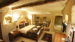 Une chambre à coucher comprenant un lit, une table de chevet et un bureau avec une chaise. Il y a aussi une salle de bain avec une baignoire et une douche.