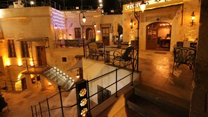 Un hôtel doté d’une terrasse, d’un escalier et d’une façade en pierre.