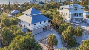 Il s’agit d’une propriété située sur la côte, comprenant plusieurs bâtiments, notamment une grande maison avec un toit bleu et une construction plus petite avec un toit blanc.