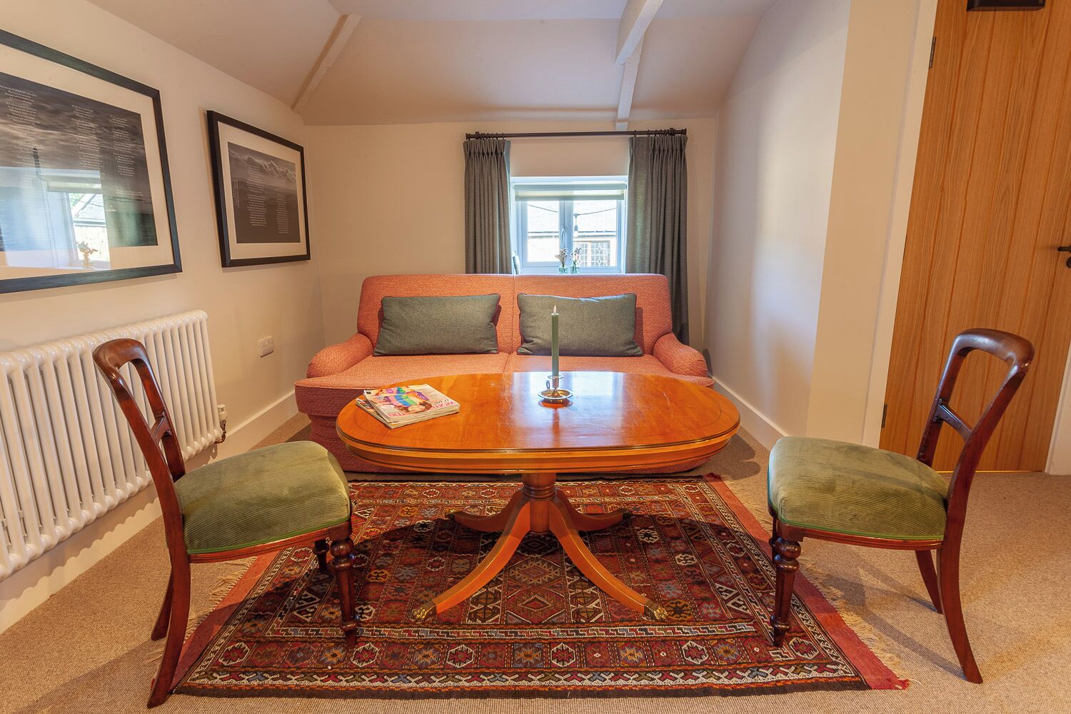 Una sala de estar acogedora con un sofá, dos sillones, una mesa de centro y un tapete estampado.