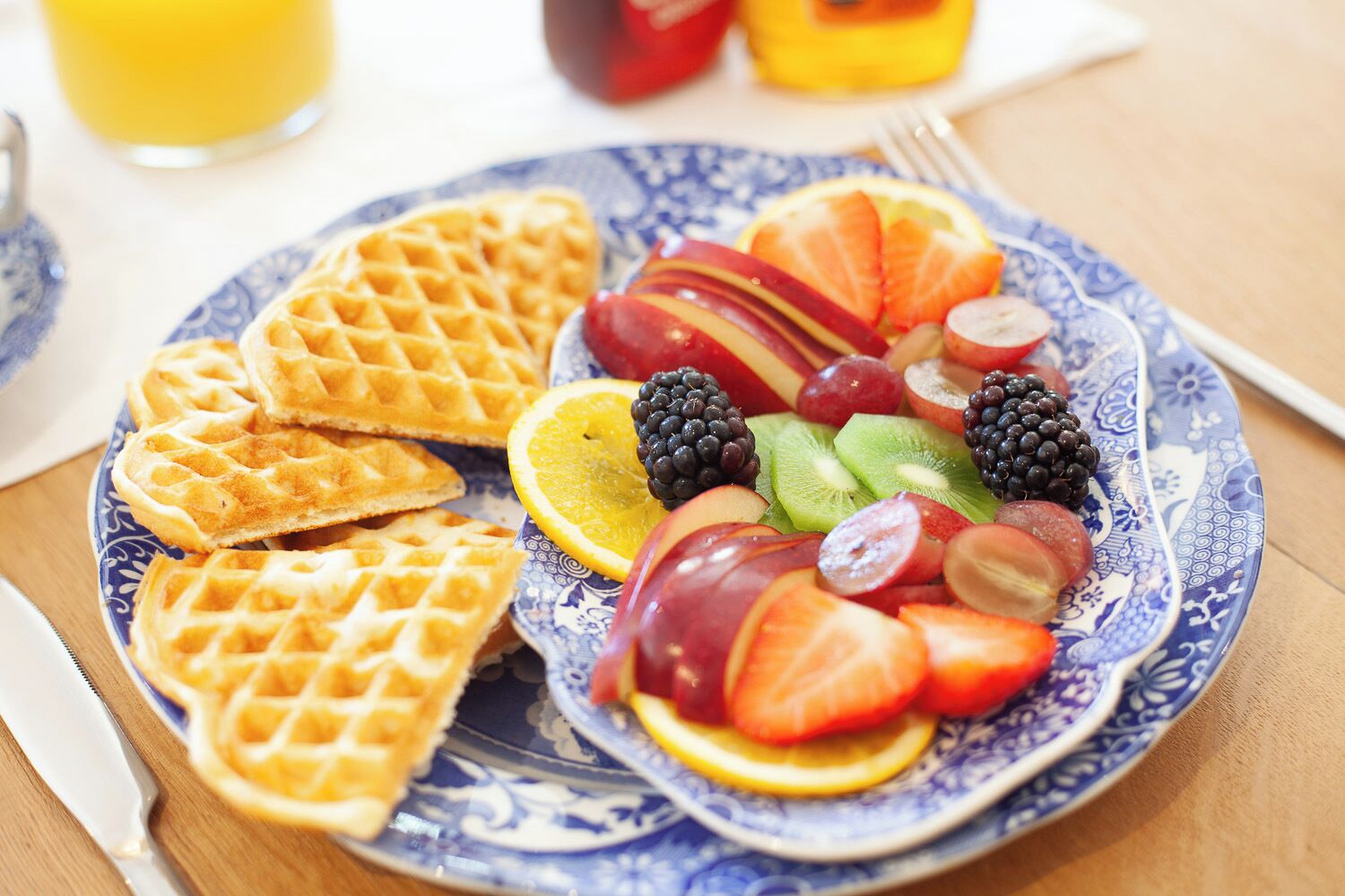 Um prato com waffles e frutas variadas.