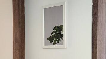Una gravada botànica emmarcada penja d'una paret senzilla.