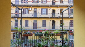 Ein Balkon mit mehreren Kübelpflanzen und einem Metallgeländer.