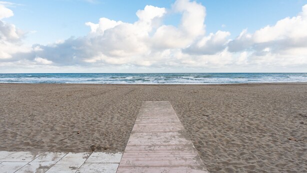 A beach with a concrete walkway leading to the water, under a partly cloudy sky. - MalagaSuite Terrace&Parking Stay Fuengirola (Fuengirola)