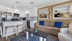 A modern kitchen with white cabinets, stainless steel appliances, and pendant lighting. - 1st Floor-Pool-Short, Easy Walk to Beach & Restaurants-Seacove 6A🌊 (MIRAMAR BEACH)
