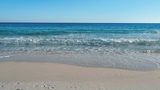 A beach with clear blue water and a sandy shore. - 1st Floor-Pool-Short, Easy Walk to Beach & Restaurants-Seacove 6A🌊 (MIRAMAR BEACH)