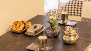 A table with pastries, a vase with flowers, a teapot, and a cup. - Charming Provençal studio with peaceful patio. Alpilles (Eyragues)
