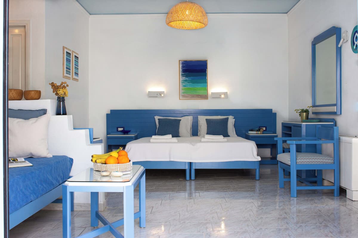 Um quarto com cama, escrivaninha, cadeira e mesa.