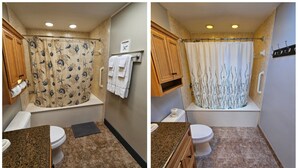Een badkamer met een douchegordijn met een zeewezenspatroon, een toilet, een wastafel met een granieten aanrechtblad en houten kastjes.