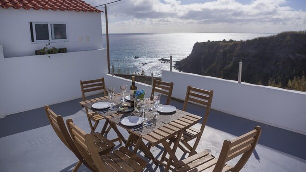 Ein Tisch für vier Personen mit Blick auf das Meer und die Klippen.