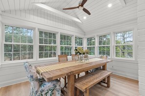 A dining area with a wooden table, benches, and chairs.