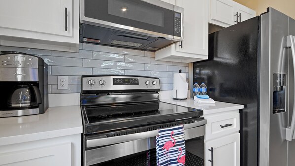 Una cocina moderna con horno negro, electrodomésticos de acero inoxidable y un dispensador de agua.