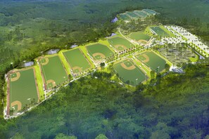 An aerial view of a sports complex with multiple baseball fields, surrounded by dense forest. - 2 Minutes Toes in Sand - Beach - Emerald Waters - Sunsets - Lagoon  (Panama City Beach)