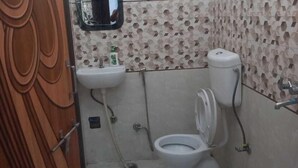 Ένα μπάνιο με τουαλέτα, νιπτήρα και καθρέφτη.