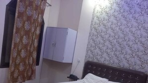 Ένα υπνοδωμάτιο με ένα ξύλινο κρεβάτι, μια ντουλάπα και μια κουρτίνα.