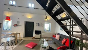A modern living room with a staircase, a dining area, and a TV. - Ourano -gastouri Village Center (Corfu)