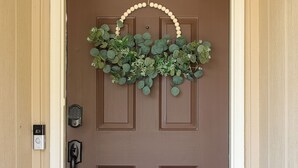 A brown door with a white frame, a doorbell, and a small mailbox. - Charming 3-bedroom home in Fayetteville: 5 min from Base (Fayetteville)