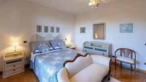 A bedroom with a bed, bedside tables, a chair, and a dresser. - Rose Corner House (Orvieto)