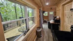 L’intérieur d’une cabane est aménagé avec du bois, il comprend un coin repas et une cuisine.