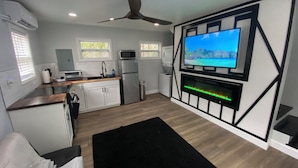 Een moderne keuken met een ingebouwde televisie, een plafondventilator en een open haard.