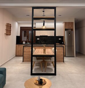 Eine moderne Küche mit einer zentralen Kochinsel, Holzschränken und einem Edelstahl-Kühlschrank.