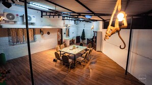 A dining area with a glass table and chairs, a hanging light fixture, and a white brick wall. - Have fun with the whole family at this Stylish 4 Bedroom private pool Villa (Lonavala)