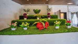 A reception area with a wooden ceiling, a white wall, and a green artificial grass floor. - Have fun with the whole family at this Stylish 4 Bedroom private pool Villa (Lonavala)