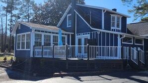 A two-story house with a porch, a covered deck, and a fenced yard. - The Salty Dog (Conway)