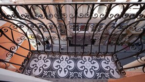 Un balcone con ringhiere in ferro battuto decorate e piastrelle a motivi decorativi.