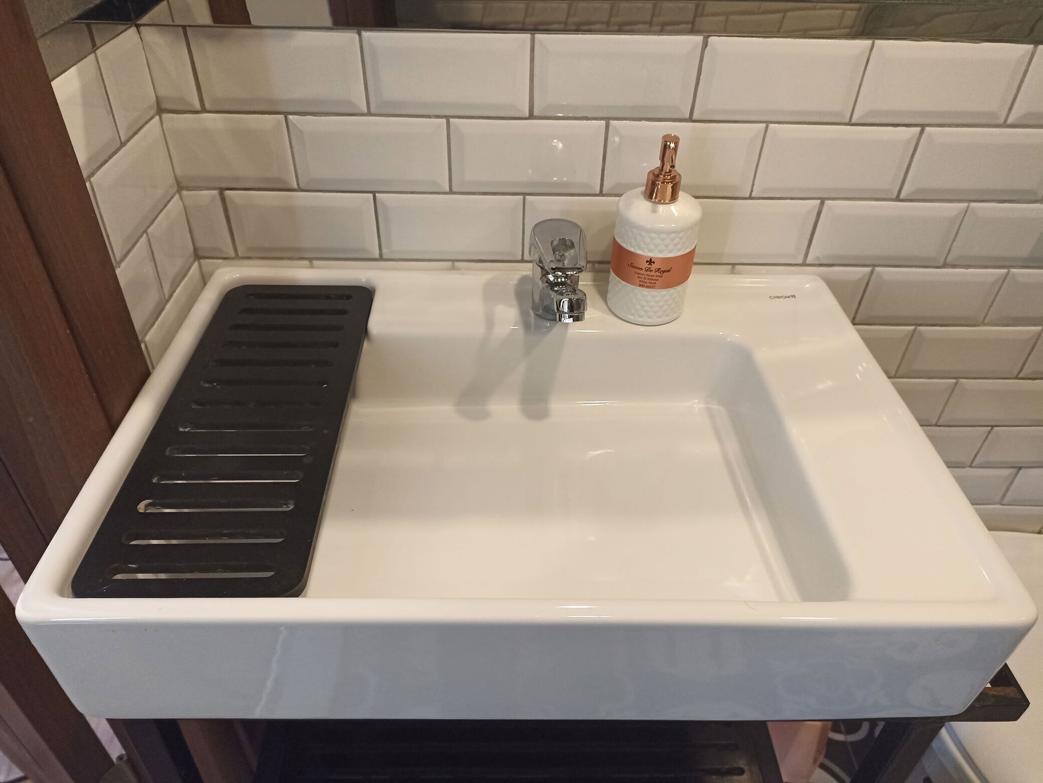 A white sink with a faucet and a soap dispenser.