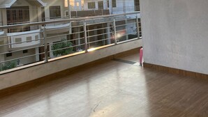 A spacious balcony with a view of surrounding buildings and a sunset. - Shri Swami Samarth Home Stay (Akalkot)