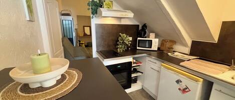 A compact kitchen with a microwave, oven, and refrigerator.