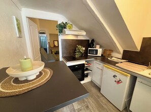 Une cuisine compacte équipée d’un four à micro-ondes, d’un four et d’un réfrigérateur.