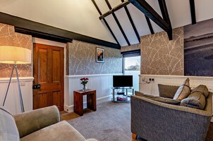 Deluxe Cottage, 2 Bedrooms, Non Smoking, Garden View | Living area | 40-inch Smart TV with cable channels