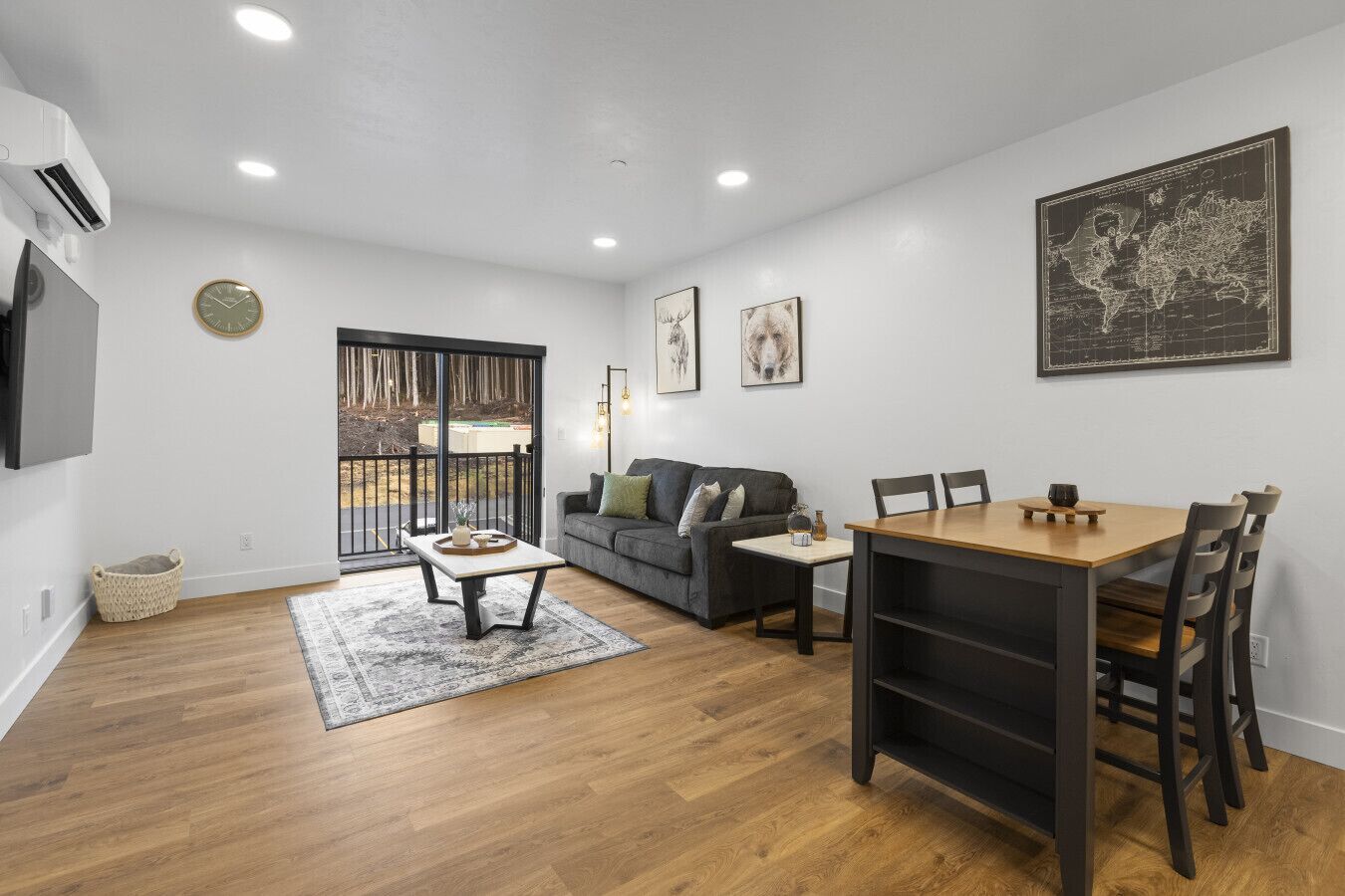 A modern living room with a sofa, a dining table, and a large world map on the wall.