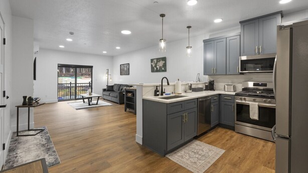 A modern kitchen with grey cabinets, stainless steel appliances, and a wooden floor. - Luxury Views, Affordable Stay A306 (Juneau)