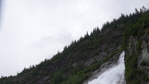 A waterfall cascading down a rocky slope into a shallow pool. - Gorgeous Views, Cozy Luxury 209 (Juneau)