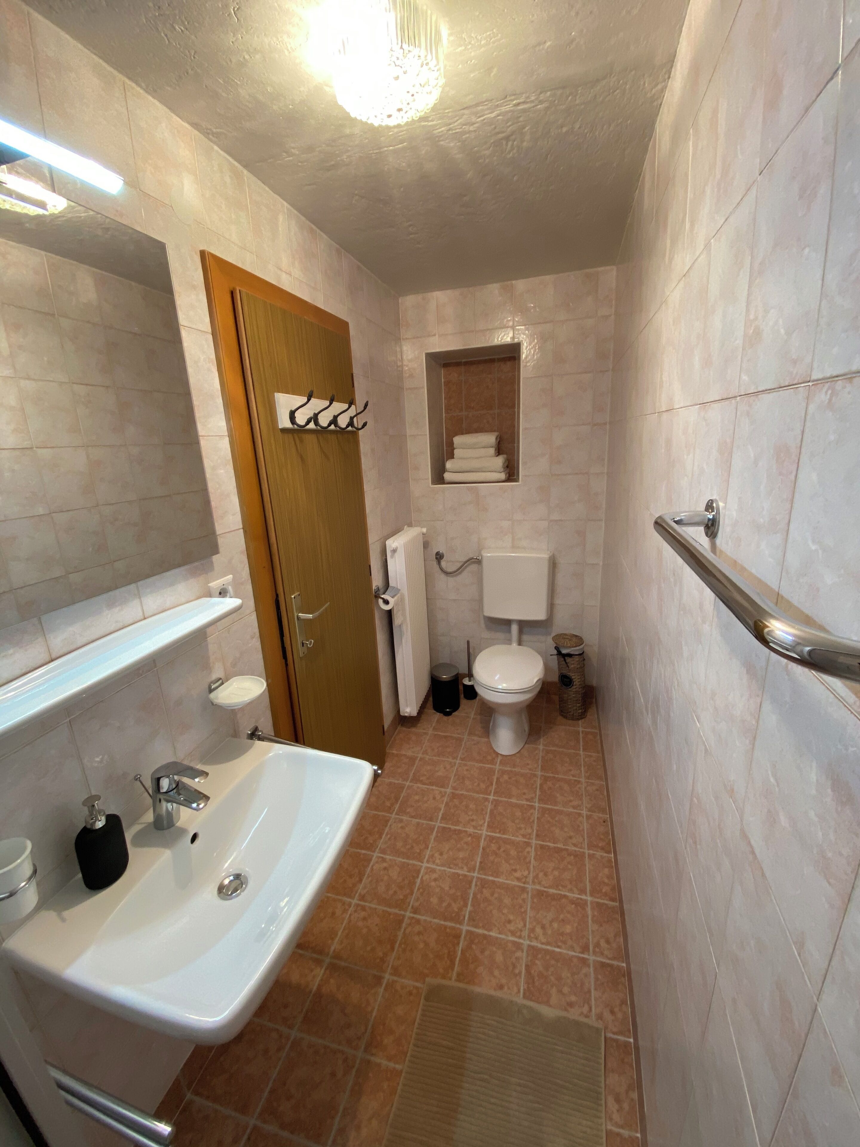 Une petite salle de bain comprenant un lavabo, des toilettes et une petite fenêtre.