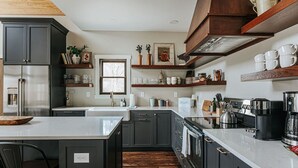 Una cocina moderna con armarios oscuros, una isla central y un ventanal.