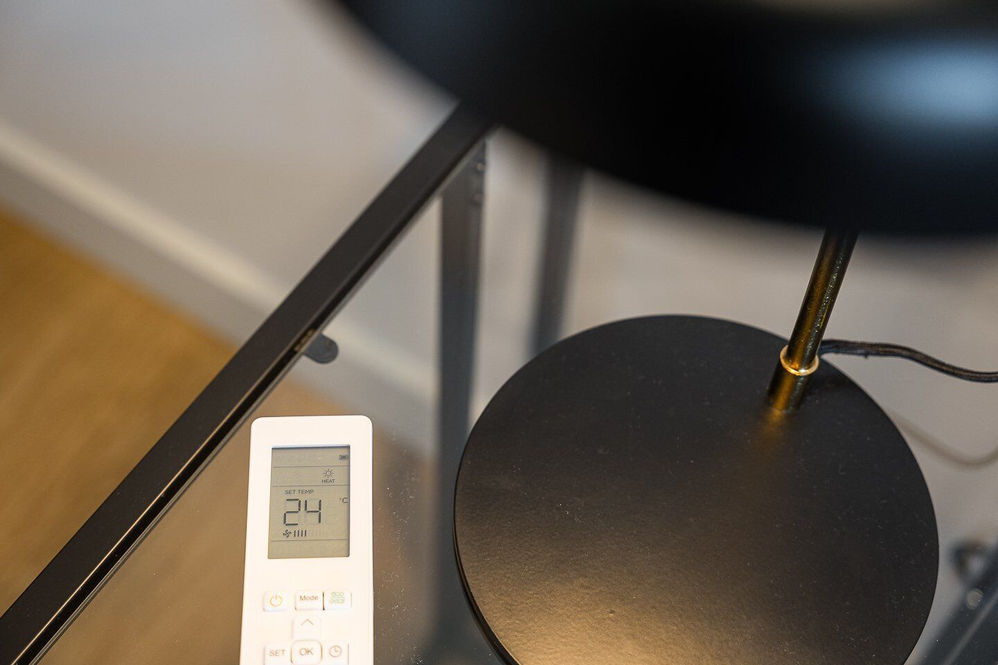 Ein Thermostat auf einem Tisch, darauf eine schwarze Lampe.