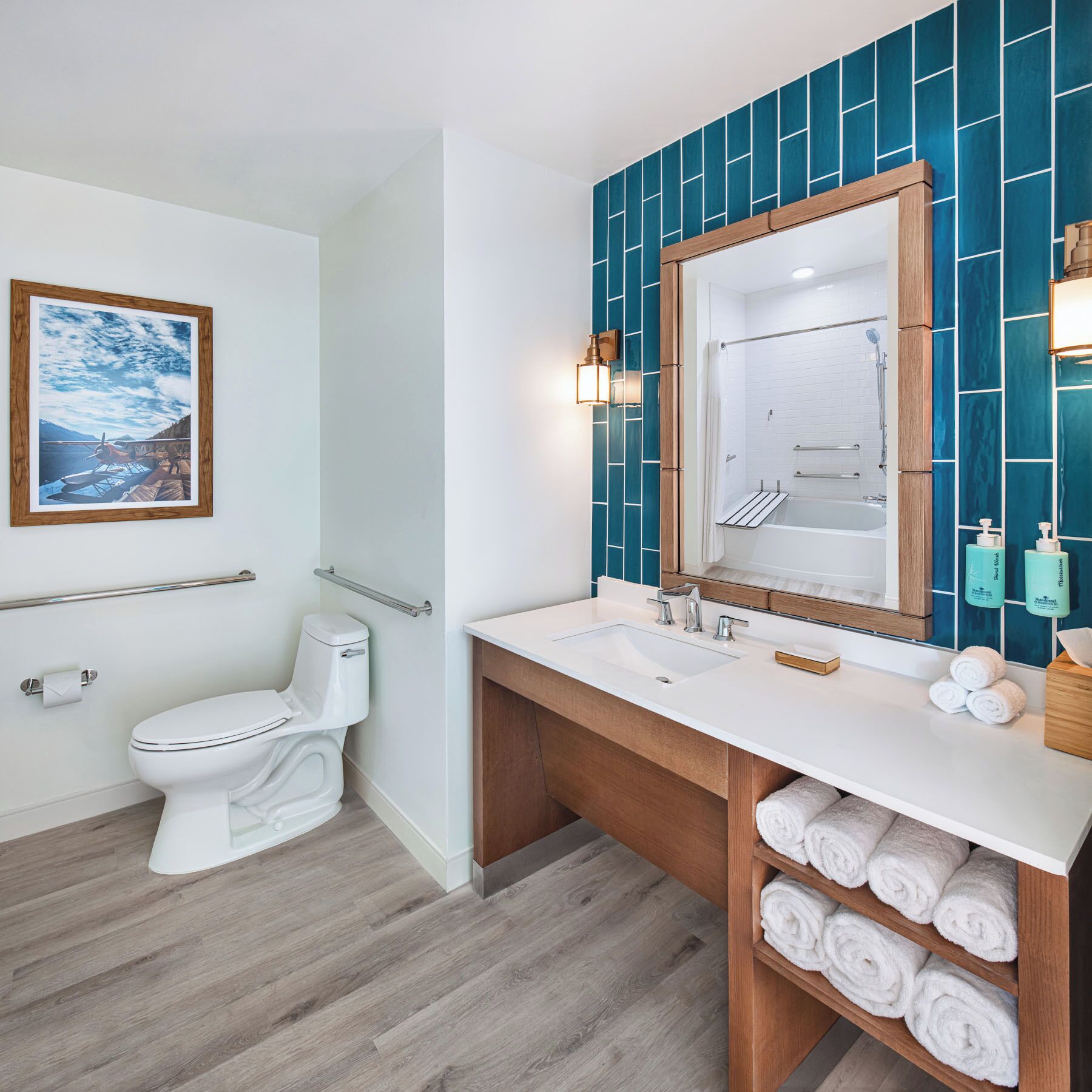 A modern bathroom with a white toilet, a large mirror, a sink, and a shower.