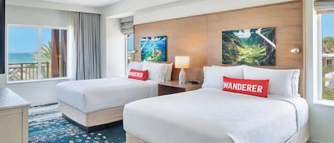 A hotel room with two beds, a large window with a view of the sea, and a wooden headboard.
