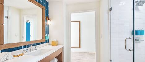 Un baño moderno con un espejo grande, lavamanos dobles y cabina de ducha de vidrio.