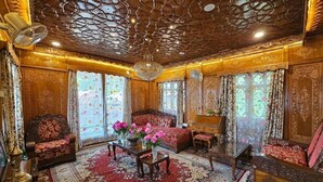 Una habitación lujosa con una cama grande, muebles ornamentados y un techo decorativo.