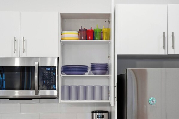 A modern kitchen with stainless steel appliances, including a microwave, oven, and refrigerator.